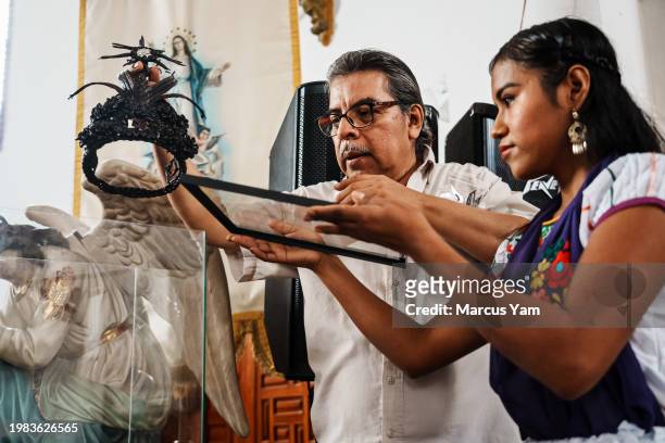 Lucio Olmos Morales retrieves the artisanal crown that he fashioned out of vanilla bean stalk, that Juanita Olarte wore during a recent corpus Cristi...