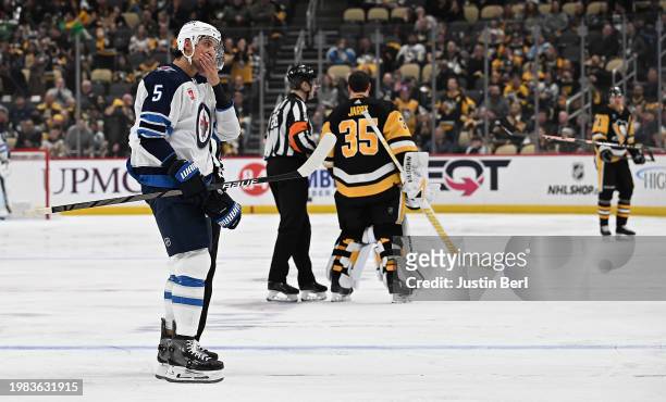 Brenden Dillon of the Winnipeg Jets is lead off the ice after receiving a match penalty for boarding in the second period during the game against the...