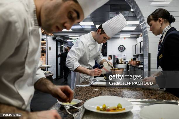 Cooks and waiters work in the kitchens of the Auberge de Collonges restaurant, in Collonges au Mont d'Or on January 26, 2024. The renovated inn,...