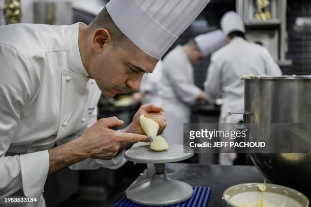 Italian chef Francesco Santin works on a dish in the kitchen of the Auberge de Collonges restaurant, in Collonges au Mont d'Or on January 26, 2024....