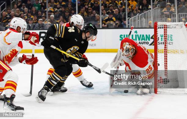 Jake DeBrusk of the Boston Bruins shoots the puck at Jacob Markstrom of the Calgary Flames during the third period the TD Garden on February 6, 2024...