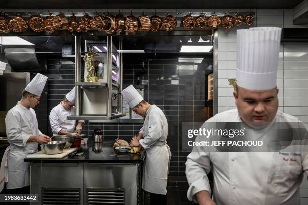 Cooks work in the kitchen of the Auberge de Collonges restaurant, in Collonges au Mont d'Or on January 26, 2024. The renovated inn, overlooked by a...