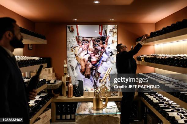 Wine steward examines a bottle in the cellar of the Auberge de Collonges restaurant, in Collonges au Mont d'Or on January 26, 2024. The renovated...