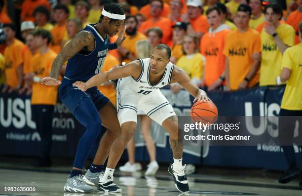 Darius Brown II of the Utah State Aggies controls the ball against Kenan Blackshear of the Nevada Wolf Pack during the first half of their game at...