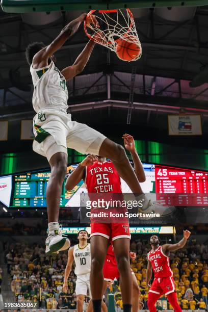 Baylor Bears center Yves Missi makes a slam dunk in front of Texas Tech Red Raiders forward Robert Jennings during the Big 12 college basketball game...
