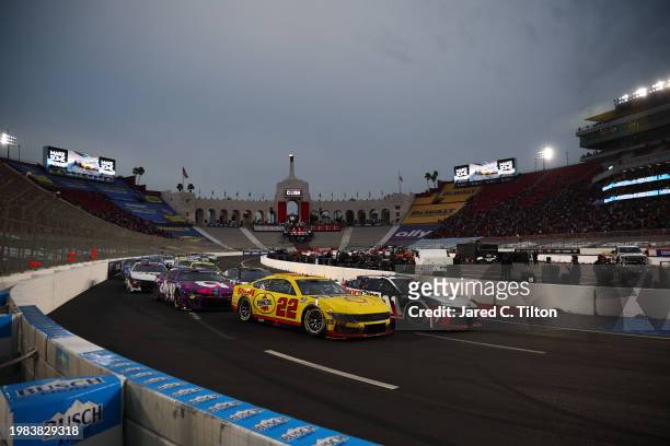 Joey Logano, driver of the Shell Pennzoil Ford, and Denny Hamlin, driver of the Sport Clips Haircuts Toyota, lead the field to start the NASCAR Cup...