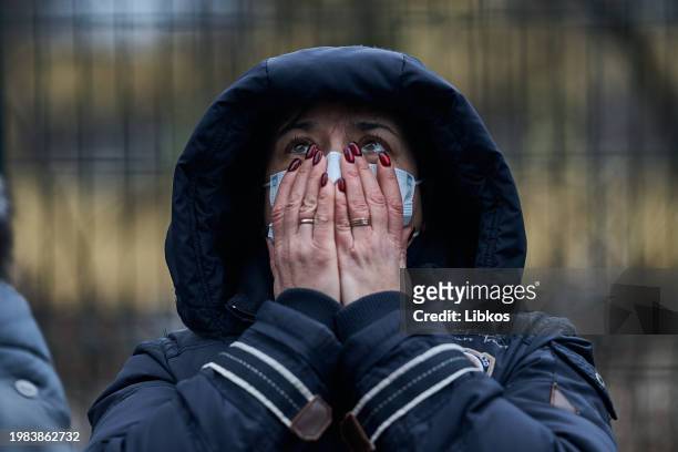 People react at the site of a missile attack in a residential area of the city on February 07, 2023 in Kyiv, Ukraine. Russia launched a massive...