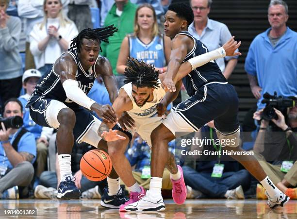 Mark Mitchell and Caleb Foster of the Duke Blue Devils pressure RJ Davis of the North Carolina Tar Heels during the second half of the game at the...