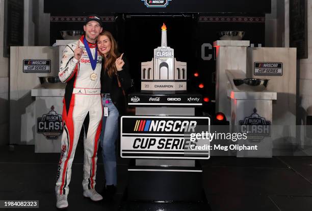 Denny Hamlin, driver of the Sport Clips Haircuts Toyota, and Jordan Fish celebrate in victory lane after winning the NASCAR Cup Series Busch Light...