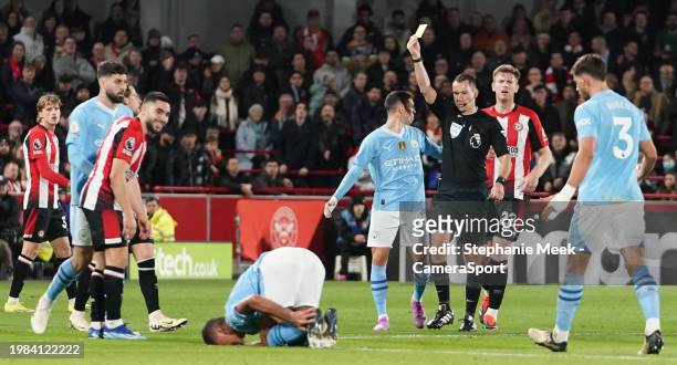 Brentford's Neal Maupay is shown a yellow card by Referee Jarred Gillett during the Premier League match between Brentford FC and Manchester City at...