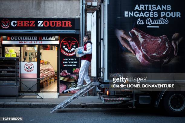 Delivery man carries boxes into a halal butcher's shop on February 7, 2024 in Toulouse, southwestern France.