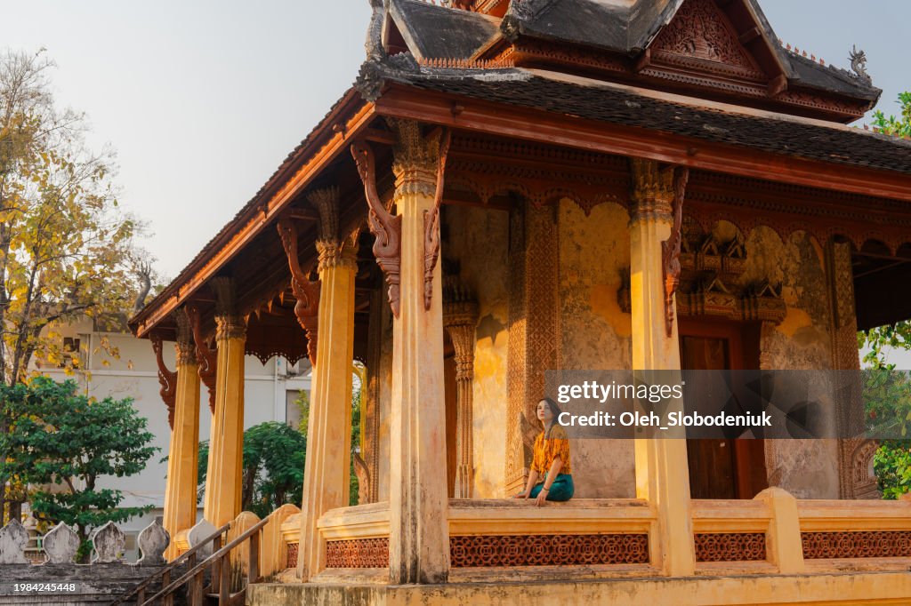 Serene woman exploring Laotian buddhist temple
