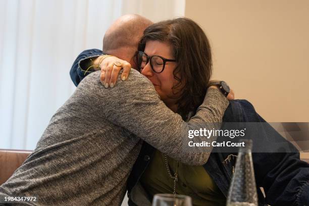 Stephen Brisley, the brother-in-law of Eli Sharab, and Sharone Lifschitz, the daughter of Oded Lifschitz, hug after a press conference to raise...