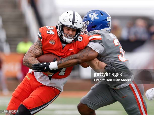 Tight End Theo Johnson of Penn State from the National Team is forced out of bounds by Linebacker Trevin Wallace of Kentucky from the American Team...