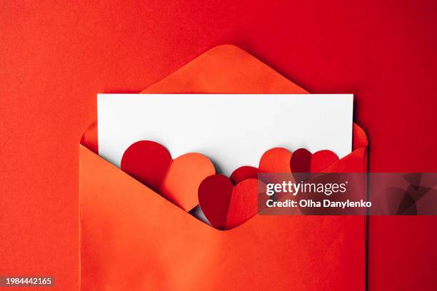 red envelope with blank card for text and paper hearts on red background - red card envelope stock pictures, royalty-free photos & images