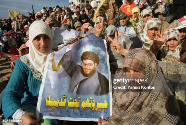 Lebanese women hold a poster of Sheikh Nasrallah, the leader of Hezbollah, during a rally, celebrating the departure of Israeli troops from southern...