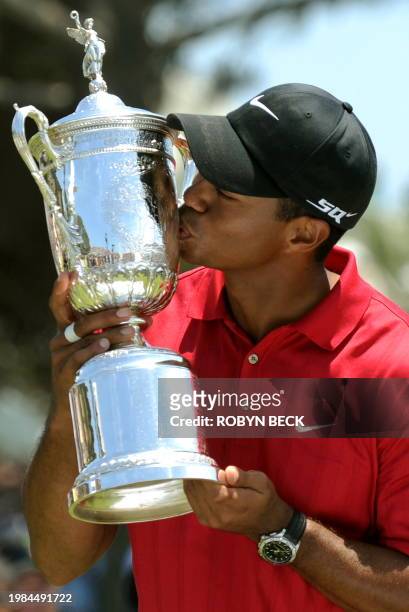 World number one Tiger Woods of the US kisses the trophy after defeating compatriot Rocco Mediate to win his third US Open title on the first hole of...
