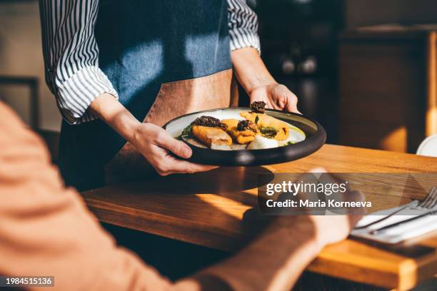 waitress serving food in a restaurant. - more customers stock pictures, royalty-free photos & images
