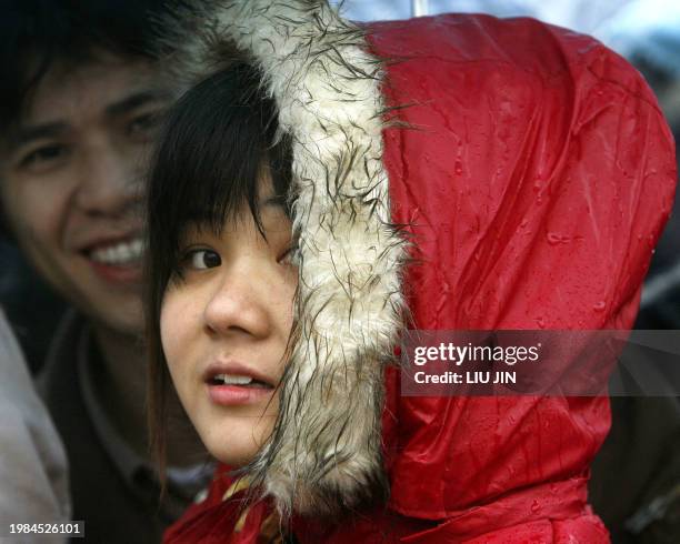 Woman stands in the rain as she wait to get on a train at the railway station, in China's southern city of Guangzhou, 02 February 2008. China warned...