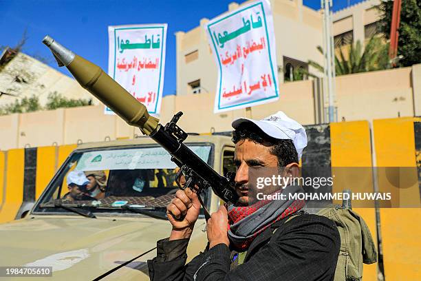 An armed supporter of Yemen's Huthi movement stands carrying a rocket-propelled grenade launcher during a pro-Palestinian rally in the Huthi-held...