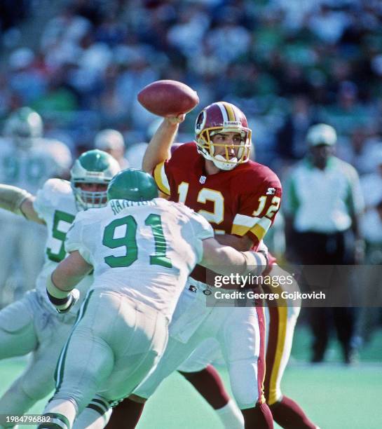 Quarterback Gus Frerotte of the Washington Redskins looks to pass as he is tackled by defensive lineman Andy Harmon of the Philadelphia Eagles during...