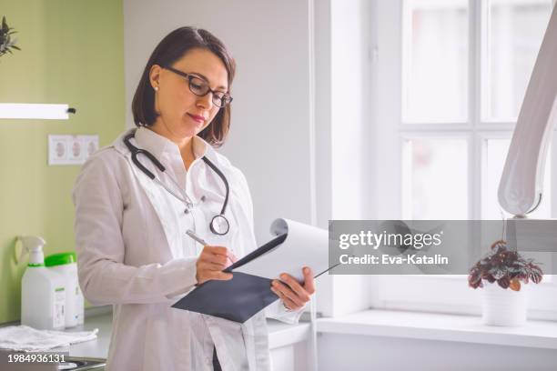 arzt in ihrem büro arbeiten - krankenstand stock-fotos und bilder