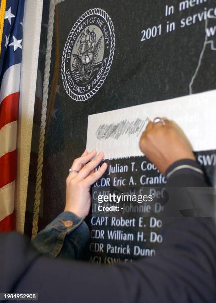 Family and friends of Navy personnel lost in the 11 September 2001 attack on the Pentagon make pencil rubbings of the names of their lost loved ones...
