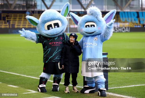 Fan of Manchester City poses for a photo with the mascots of Manchester City, Moonchester and Moonbeam, prior to the Barclays Women's Super League...