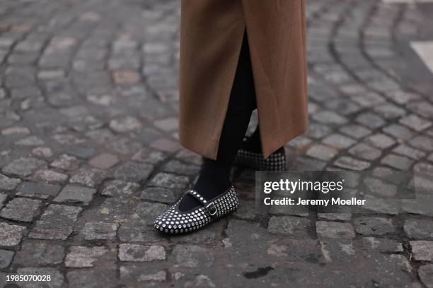 Fashion week guest is seen wearing a brown wool coat, black tights and black silver rhinestone ballerinas during the Haute Couture Spring/Summer 2024...