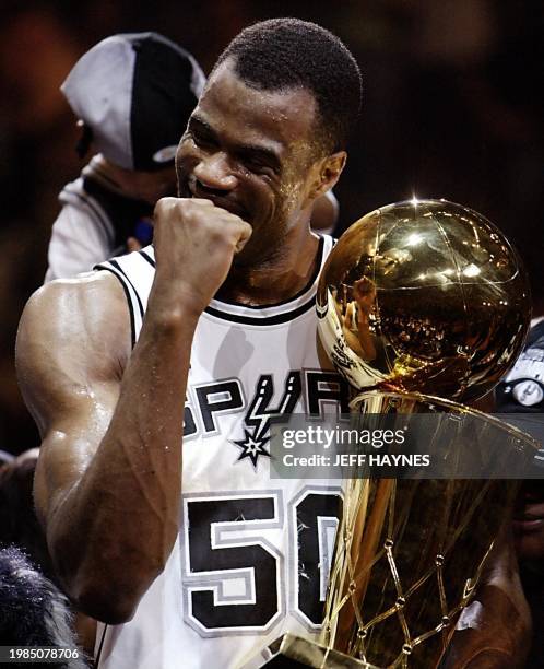 David Robinson of the San Antonio Spurs hold the Larry O'Brian Championship trophy after beating the New Jersey Nets in game six of the NBA Finals at...