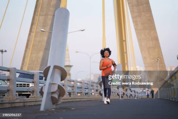 motion of young woman jogging exercise in the morning on the bridge - green vest stock pictures, royalty-free photos & images