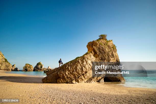 touristisches klettern am strand von ribeiro do cavalo - cavalo stock-fotos und bilder