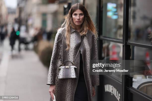 Veronika Heilbrunner is seen wearing a long gray and white wool coat with a snake look, the matching Peekaboo crossbody bag in gray and white and the...