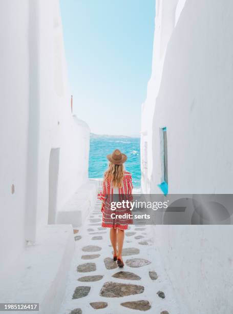 giovane donna turista cammina per le strade dell'isola di mykonos, cicladi, grecia - grecia foto e immagini stock