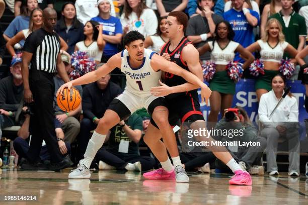 Joel Scott of the Colorado State Rams tries to dribbles around Elijah Saunders of the San Diego State Aztecs during a college basketball game at the...