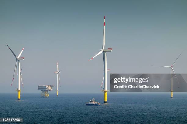 epic sunrise over offshore wind farm and substation on the horizont, vessel between them, bright sky, borkum riffgrund germany - oljeplattform bildbanksfoton och bilder