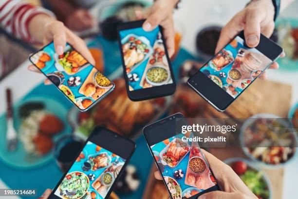 personas tomando fotos de la comida con sus teléfonos - social media fotografías e imágenes de stock