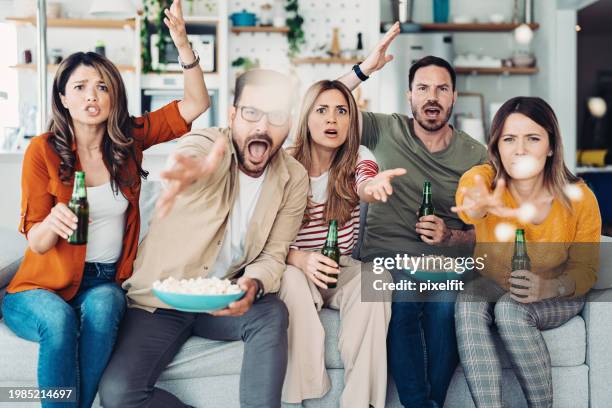 disappointed sport fans shouting and throwing popcorns against the tv - home game sport stock pictures, royalty-free photos & images
