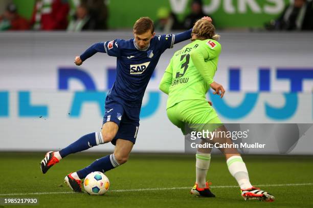 Maximilian Beier of TSG 1899 Hoffenheim runs with the ball whilst under pressure from Sebastiaan Bornauw of VfL Wolfsburg during the Bundesliga match...