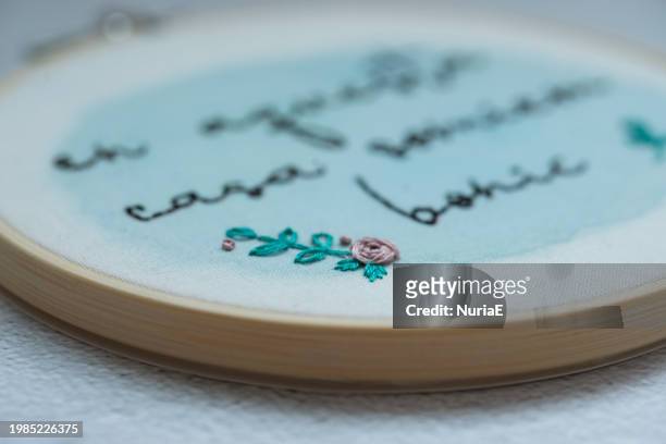 close-up of an embroidery hoop with a floral decoration and spanish text - nuria stock pictures, royalty-free photos & images
