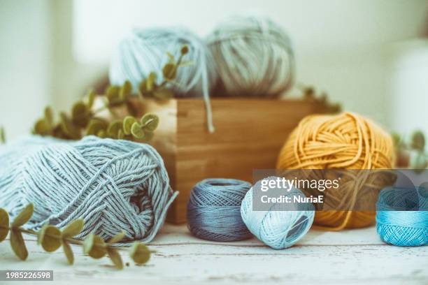 close-up of skeins of thread and wool in a wooden box on a table with foliage - nuria stock pictures, royalty-free photos & images