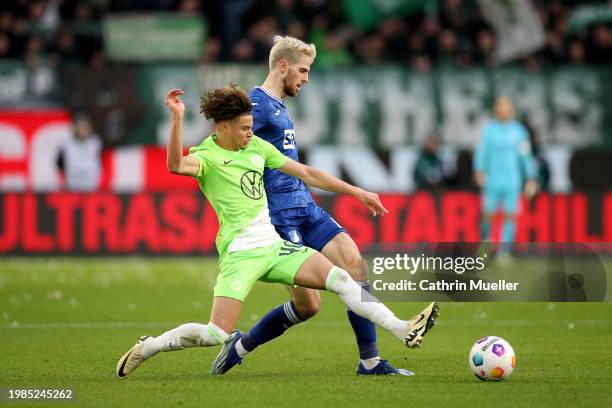 Anton Stach of TSG 1899 Hoffenheim is challenged by Kevin Paredes of VfL Wolfsburg during the Bundesliga match between VfL Wolfsburg and TSG...