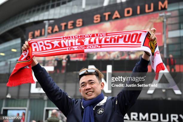Fan poses for a photo outside the stadium whilst holding a match day scarf prior to the Premier League match between Arsenal FC and Liverpool FC at...