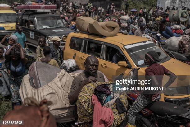 Man sits on his motorbike while carrying some of his belongings as people flee the Masisi territory following clashes between M23 rebels and...