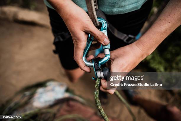 primer plano de un escalador poniéndose el equipo de seguridad antes de escalar montañas - artículo de montañismo fotografías e imágenes de stock