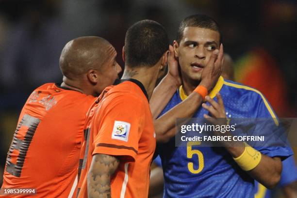 Netherlands' midfielder Nigel de Jong touches Brazil's midfielder Felipe Melo after he committed a foul on Netherlands' striker Arjen Robben and got...