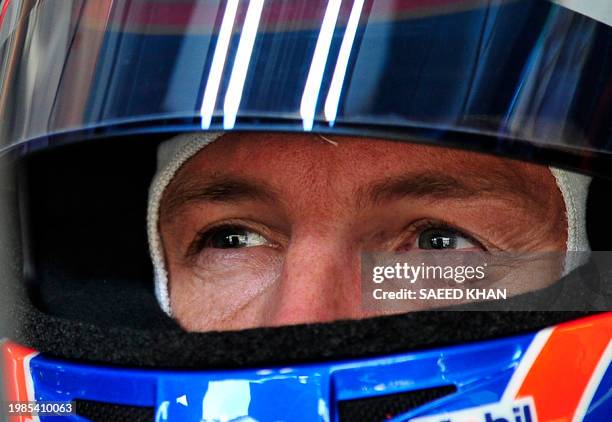 McLaren-Mercedes driver Jenson Button of Britain monitors circuit on an electronic screen while sitting inside his car during the third practice...