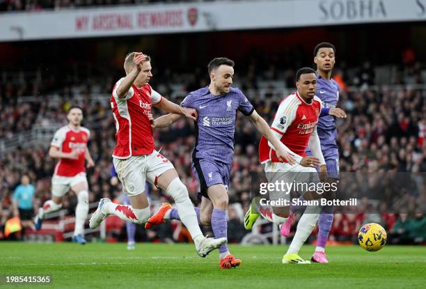 Diogo Jota of Liverpool runs with the ball whilst under pressure from Oleksandr Zinchenko and Gabriel of Arsenal during the Premier League match...