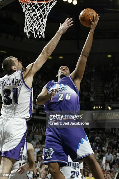 John Amaechi of the Utah Jazz shoots past Scot Pollard of the Sacramento Kings in Game five of the Western Conference Quarterfinals during the 2003...