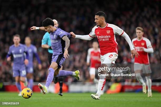 Luis Diaz of Liverpool runs with the ball whilst under pressure from William Saliba of Arsenal during the Premier League match between Arsenal FC and...